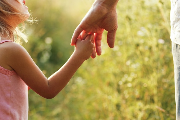 Руки родителей и ребенка на открытом воздухе в парке