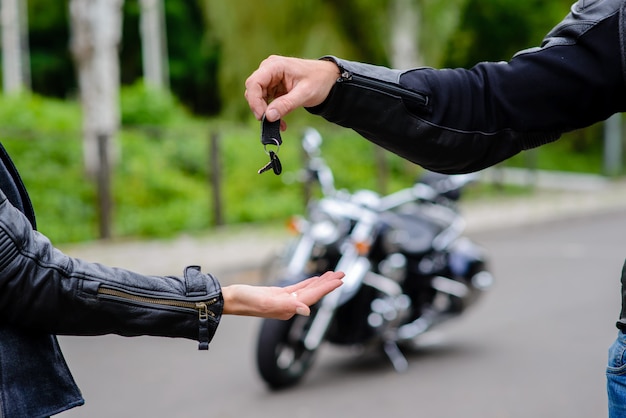 Hands pass the keys to the motorbike.