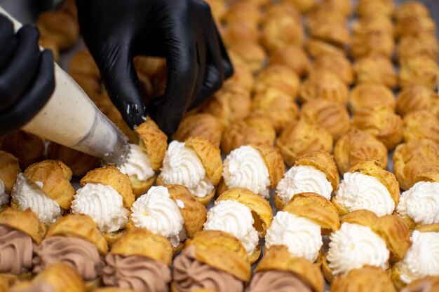 Hands of pastry chef filling sweets