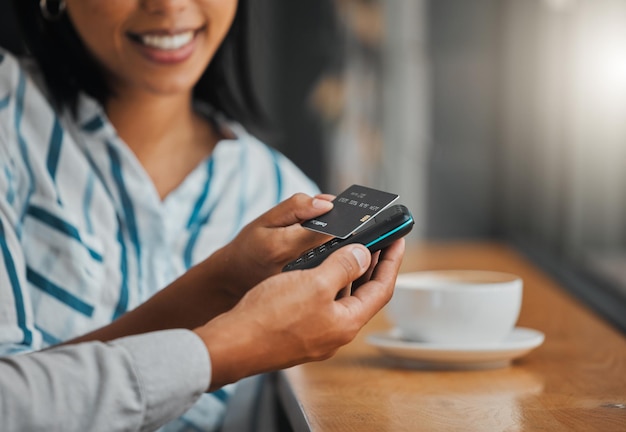 Hands paying bill with credit card payment for coffee or tea at cafe coffee shop or restaurant close up Woman making cashless purchase with help and assistance from store worker employee or waiter