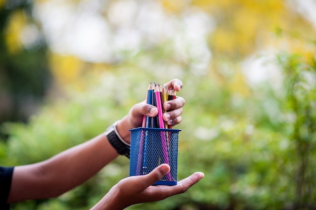 Photo hands and pencils in many colors