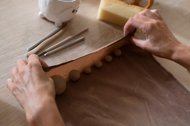 Hands of people working in pottery workshop