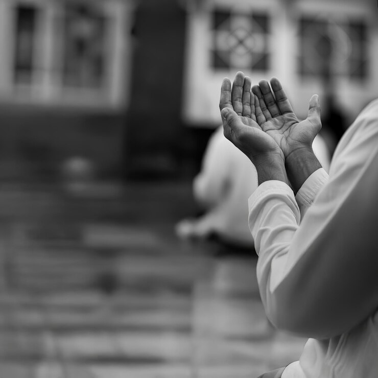 Photo hands of a person praying in ramadan hands raised in a prayerful gesture in black and white