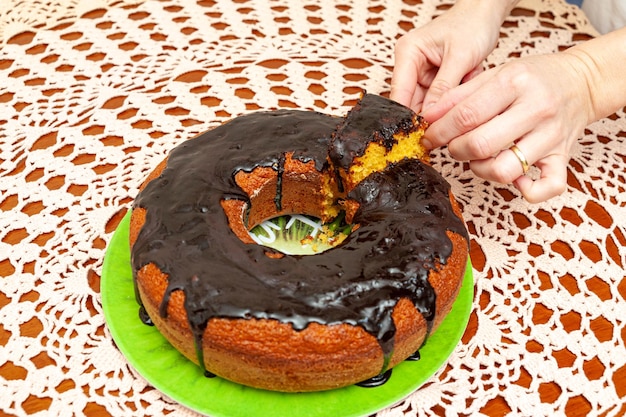 Hands picking up a piece of the delicious and healthy traditional Brazilian homemade carrot cake