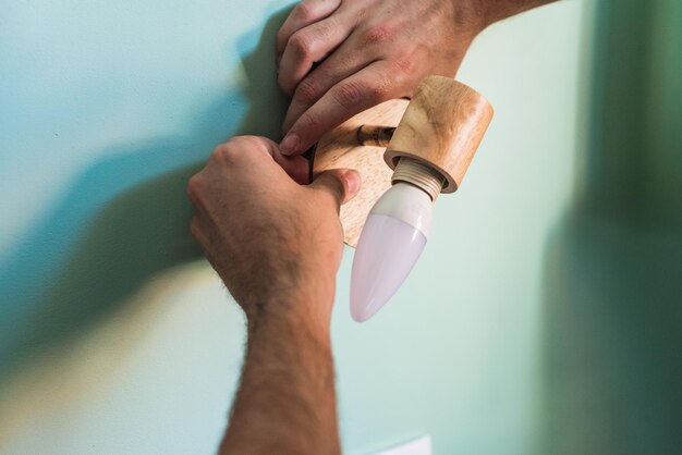 Hands placing a wall lamp Light for the bedroom