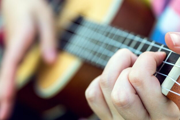 Hands playing a guitar closeup