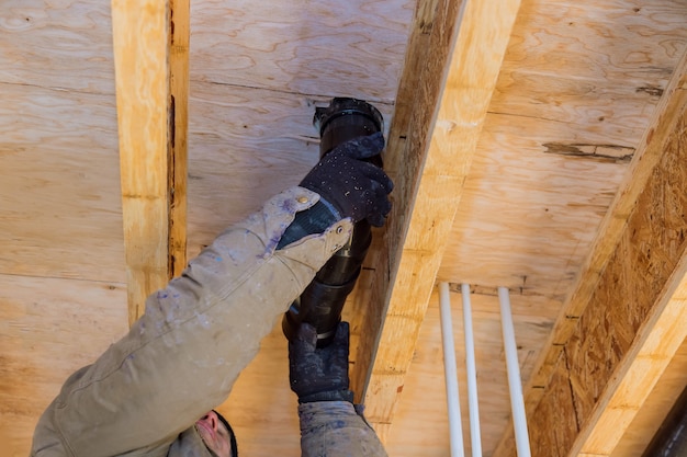 Hands plumber in installing of plastic drains PVC pipe, closeup on new bathroom