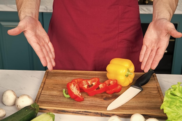 Hands point at pepper slices vegetable and ceramic knife