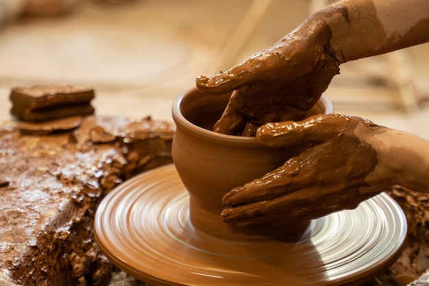 Hands of a potter creating an earthen jar on the circle woman makes hand made ceramics from clay