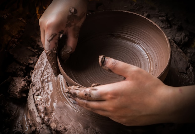 hands of a potter, creating an earthen jar on the circle