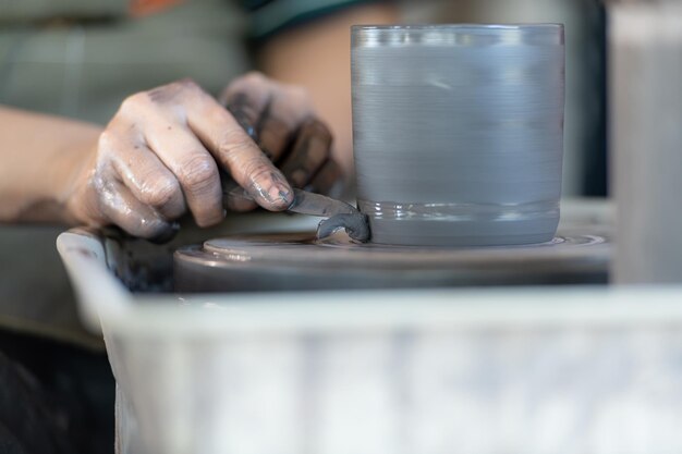 hands of a potter creating an earthen jar on the pottery wheel