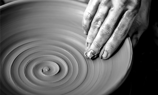 Hands of potter making clay pot, closeup photo