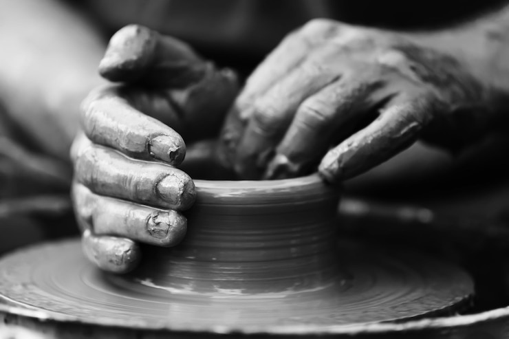 Photo hands of a potter potter making ceramic pot on the pottery wheel