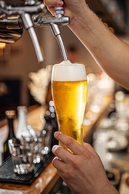 Hands pouring draught beer into a glass