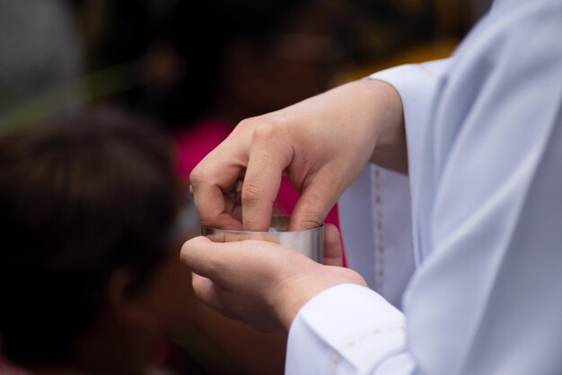 Photo hands of a priest taking the hostia receiving the body of christ