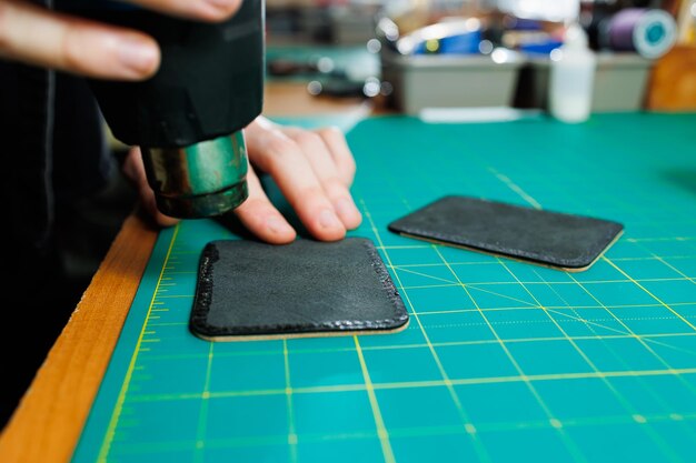 Hands of a professional craftsman make a leather wallet new clean genuine leather wallet closeup cropped shot