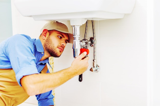 hands of professional plumber fixing pipes. plumbing repair service.