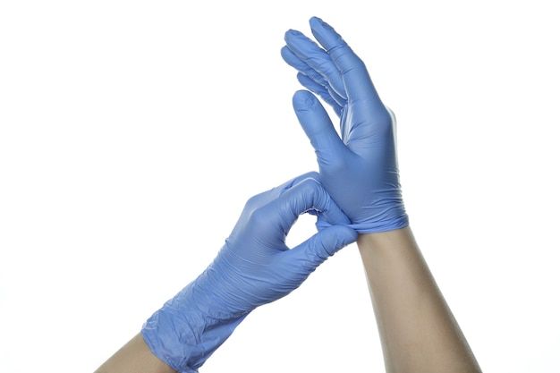 Hands putting on medical gloves, isolated on white