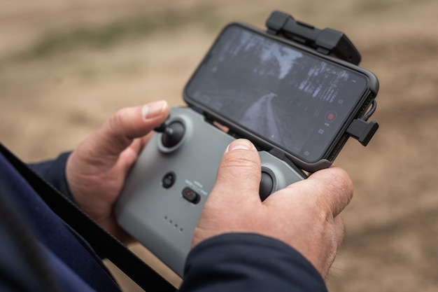 Hands in remote controller to control a drone close up