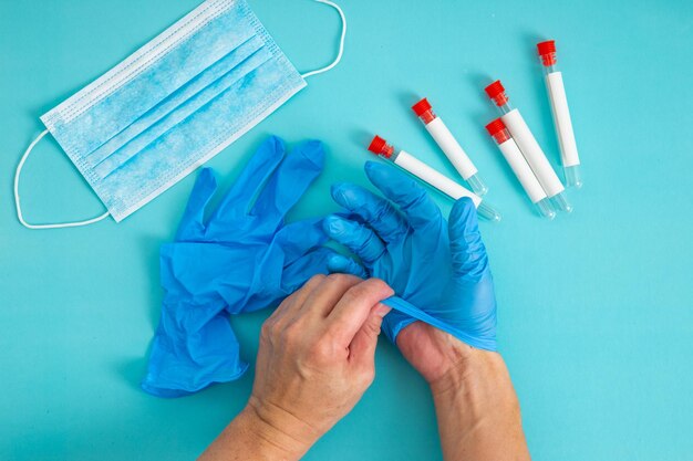 Hands remove glove on blue background