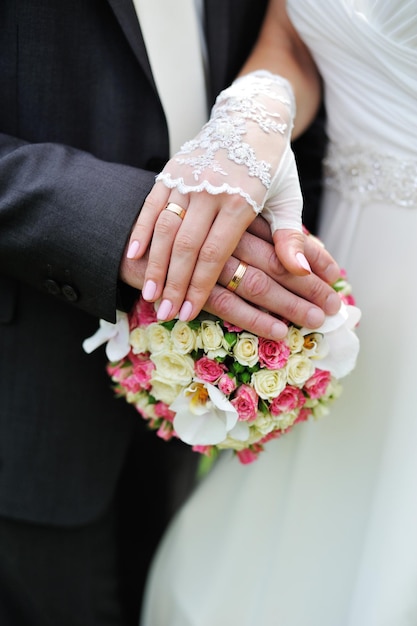 Hands and rings on wedding bouquet