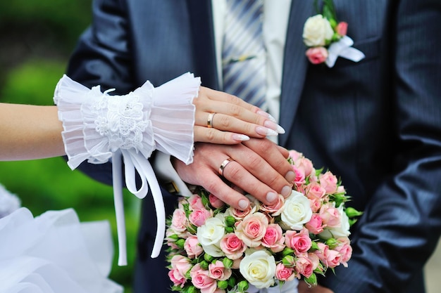 Hands and rings on wedding bouquet