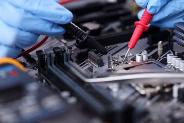 Hands in rubber gloves repairing computer closeup. Maintenance and repair of computer equipment and electronics concept