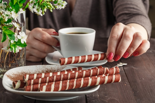 一杯のコーヒーを保持している年配の女性の手