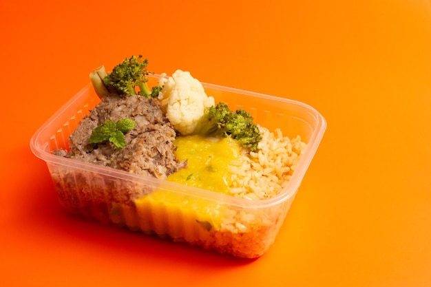 Hands serving packed lunch box home prepared meal in aerial top view close up empty space isolated