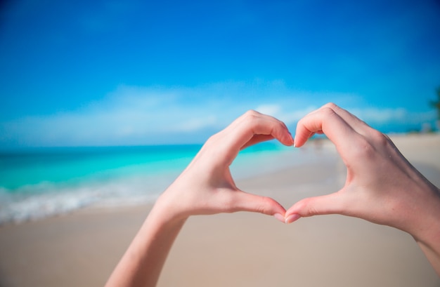 Hands in the shape of heart on the background of the Caribbean Sea