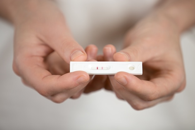 Руки, показывая тест на беременность