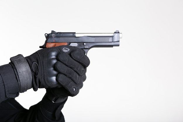 the hands of a soldier are holding a pistol gun