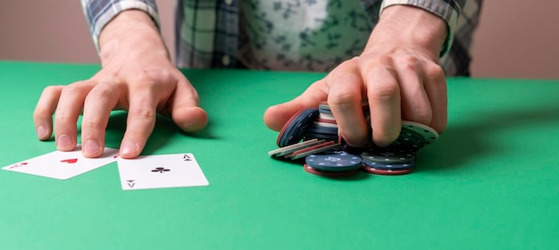 The hands take the casino poker chips on the green table, gambling and luck concept