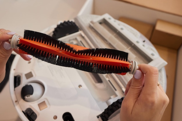 Hands take out a robot vacuum cleaner from the box New purchase