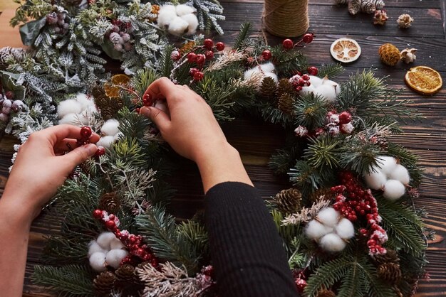 Hands taking care of ornament. Top view of christmas festive frame with new year decorations.