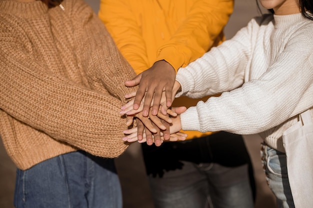 Foto le mani di tre persone tese in solidarietà