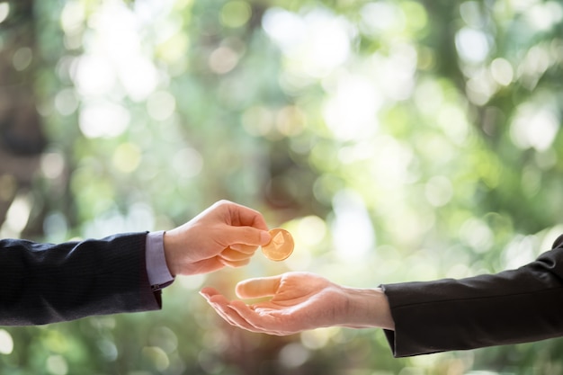 Hands of two businessman are trading coin of ethereum.