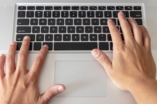 Hands typing on computer keyboard