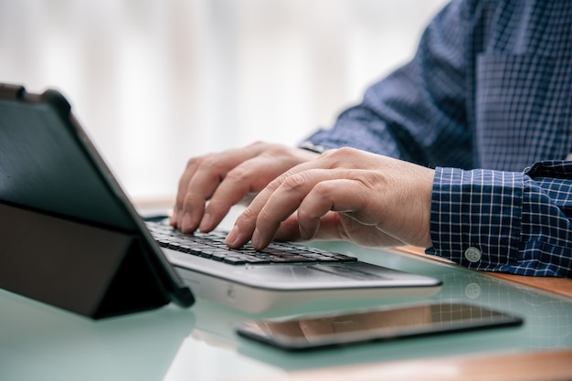 Foto mani che digitano computer durante il telelavoro