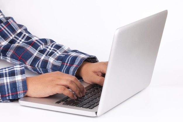 Hands typing on keyboard of laptop on white background