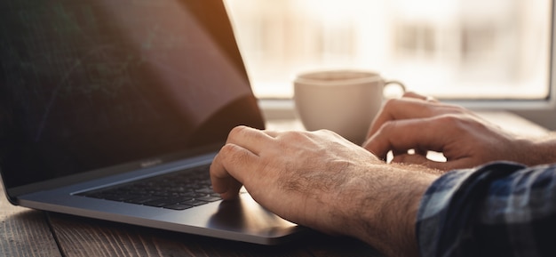 Hands typing on the keyboard of a laptop