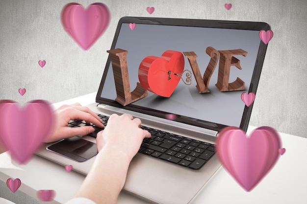 Hands typing on laptop against white and grey background