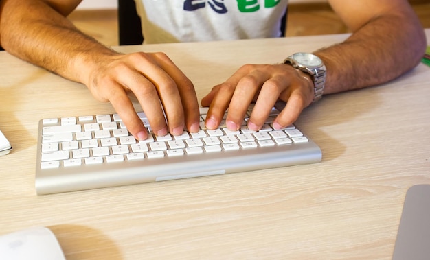 Photo hands typing on a laptop in office