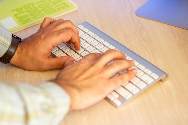 hands typing on a laptop in office