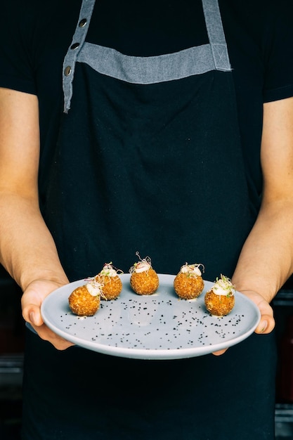 Hands of an unrecognizable person holding a plate of food.