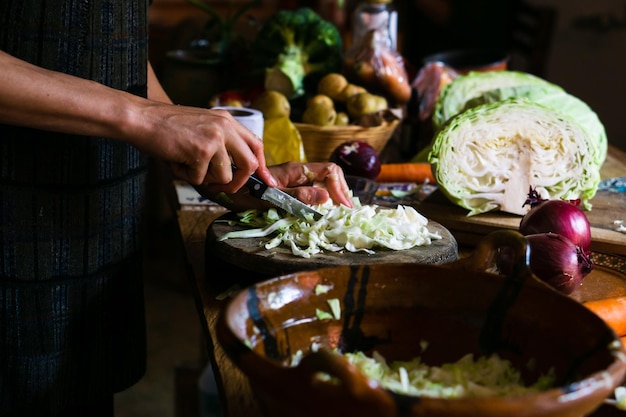 Hands of an unrecognizable person preparing a salad. Healthy food.