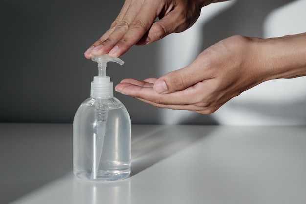 Hands using alcohol sanitizer gel pump for prevent infection