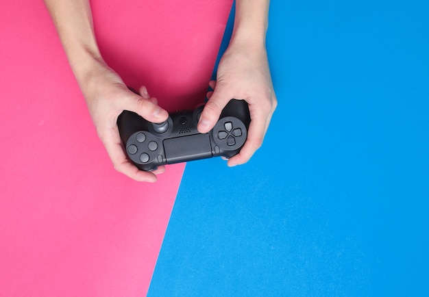 Hands using gamepad on colorful background