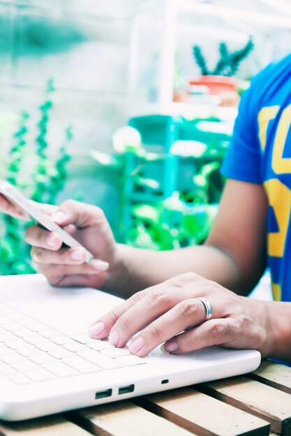 Hands using laptop and phone for online shopping