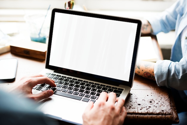 Hands using laptop with blank screen